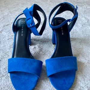Helt nya klackar/ stl 39/ oanvända - Superfina sandaletter i blå mockaimitation. Vacker ankelrem med spänne och justerbar knäppning. Stabil klack i 8 cm. Helt oanvända, från Dinsko. Storlek 39. Säljes då jag rensar i garderoben. Skriv gärna vid frågor.