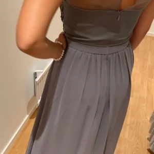 Festklänning i grå med mesh  - Grå klänning med mesh och fina detaljer upptill. Klänningen är endast använd en gång. Passar storlek 34/36. Köparen står för frakt.