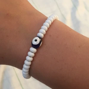 Vitt armband! - Detta är ett fint vitt armband med en blå pärla i mitten. Man kan dra åt den mer eller minder om man vill det. 💓 säljer denna för 15kr + 5kr frakt!