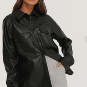 Skinnskjorta  - Jag säljer denna jätte fina skinnskjortan då den inte kommer till användning. Den är ifrån na-kd och är i fint skick. Den är i storlek 34. Hör av dig om du har frågor/ är intresserad 💗🌸