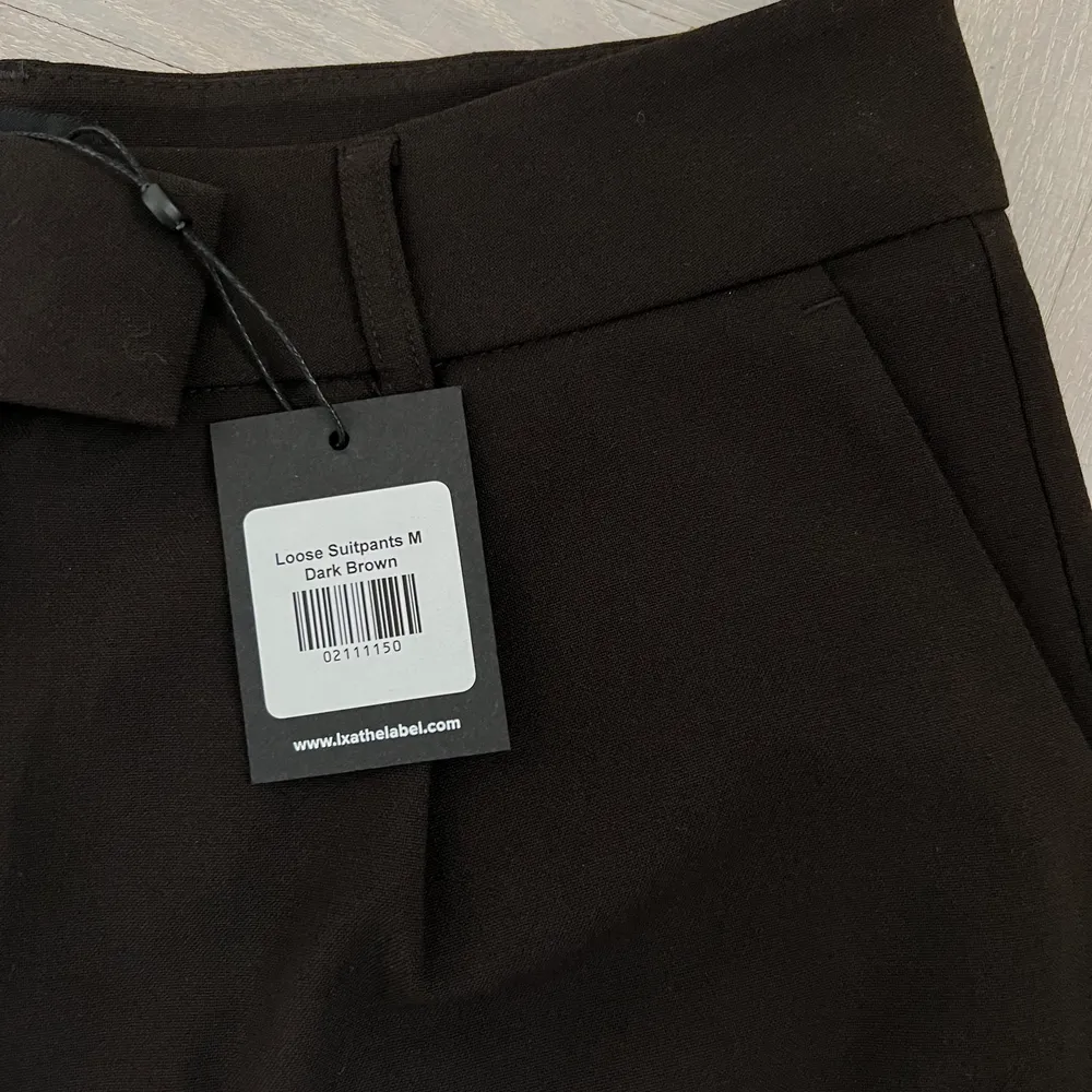 Aldrig använda, helt nya kostymbyxor från LXAthelabel, Linn Ahlborgs märke. De är i en mörkbrun färg i storlek M. Väldigt långa i benen. Nypris 699kr.. Jeans & Byxor.