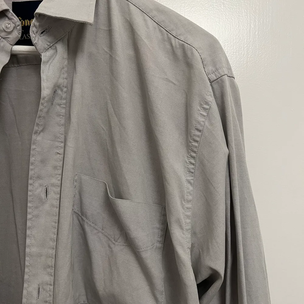 Ljusgråskjorta i 100% bomull, ingen märkning men sitter som en L-XL. Skjortor.