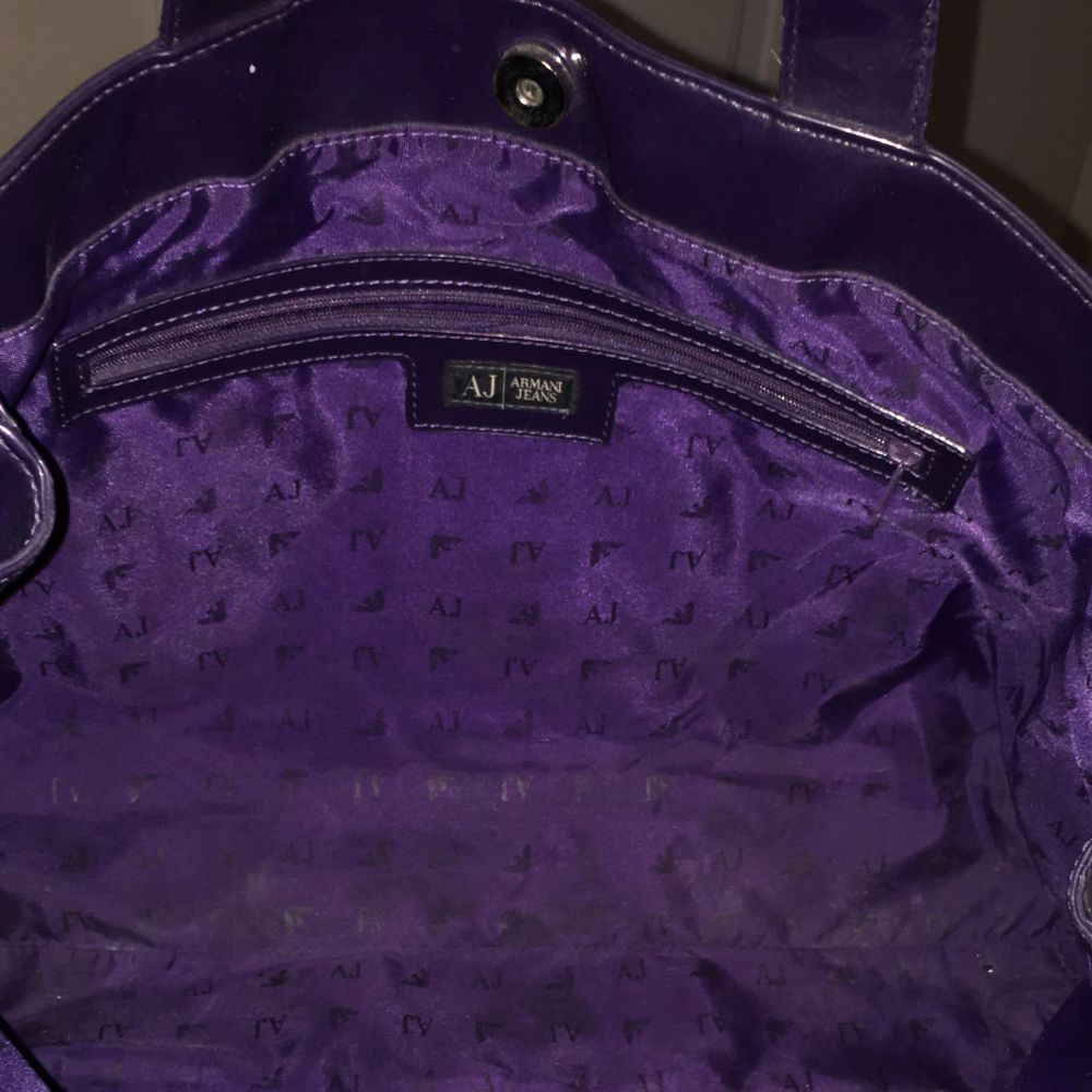 Armani jeans handväska i lila färg och en dust bag. Vaska är av pvc-plasten .väska model är  Armani Jeans diamond shopper bag. Toppskick och rent.40x 28x 12 cm. Väskor.