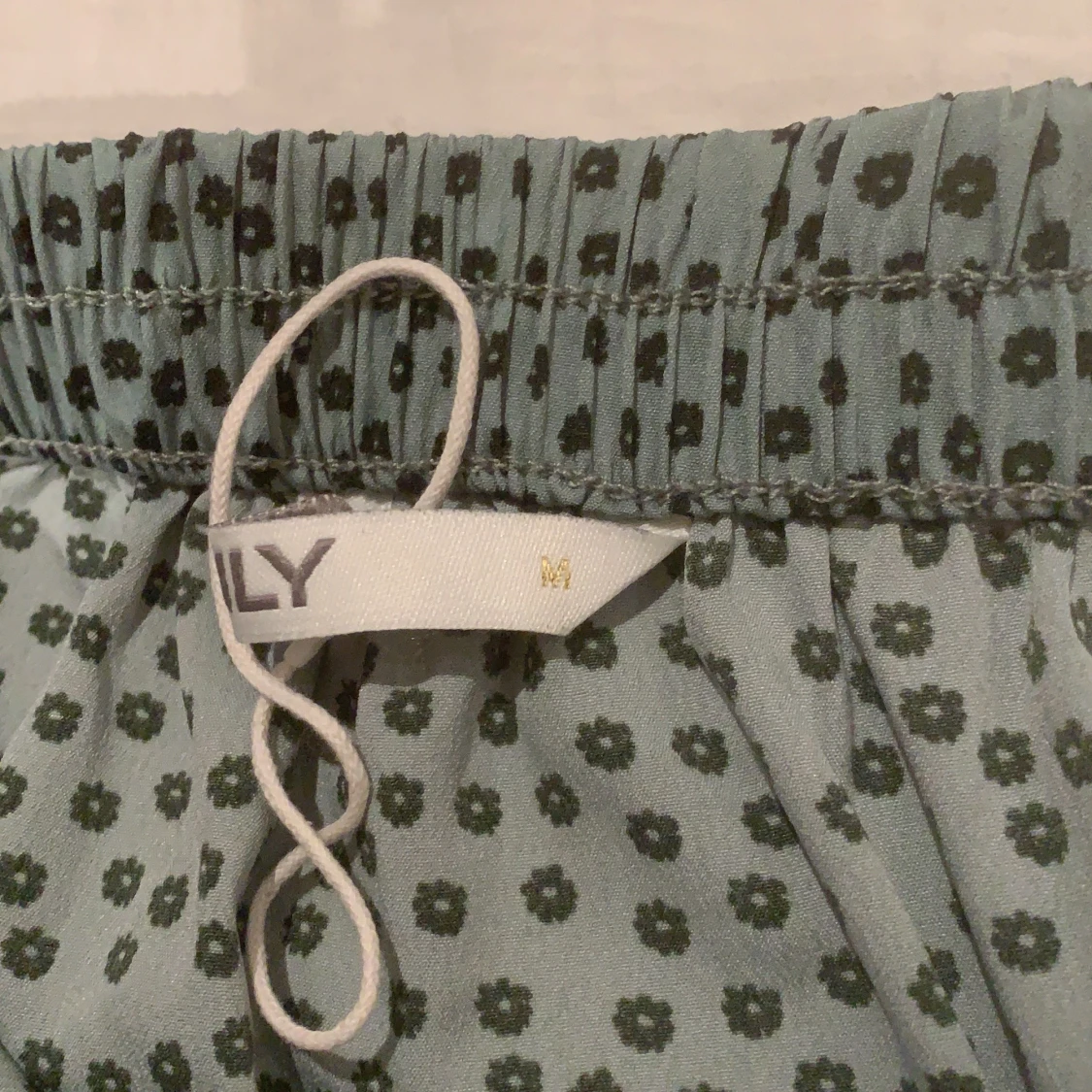 grön kort kjol med svarta små blommor på - 91