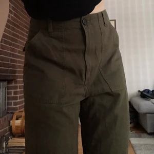 Mörkgröna byxor - Raka, mörkgröna jeans från H&M med stora framfickor samt två fejk-bakfickor. Storlek 38. Fler bilder finns! Köpare står för frakt.