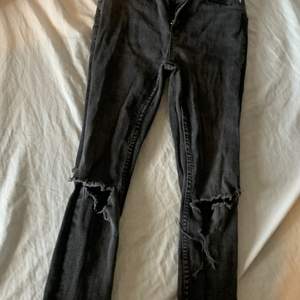 Ett par svarta jeans st XS ett hål i knät 