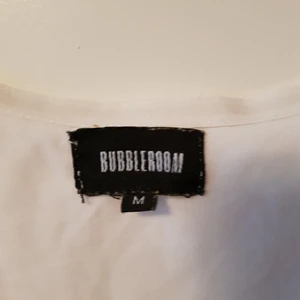 Vit blommig klänning i storlek M.  - En vit blommig klänning. Använd 1 gång. Inget fel. Köpt från Bubblerooms hemsida.