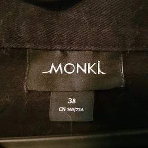 Svart kjol med knappar i storlek M. - Svårt kjol med knappar. Inga fel. Kan ha päls på sig (har katter). Köpt på Monki.