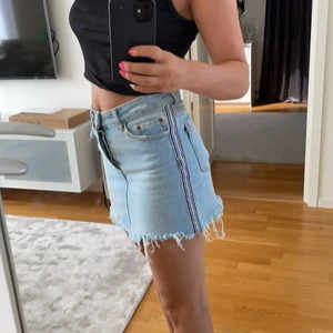 Jeans kjol - En blå jeanskjol med en cool detalj på sidan. Kjolen är från Bershka och i mycket bra skick. Storleken är 34 men passar mig nog en liten 36 också (den passar mig som brukar ha 36). 