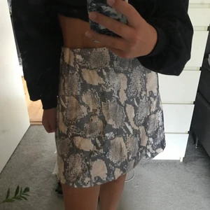 Satinkjol från H&M - Säljer denna otroligt snygga satinkjolen med ormskinnsmönster från H&M!🤍köpt för nån månad sen och är inte använd så är så gott som ny!! Säljs pågrund av att det var tyvärr fel storlek för mig:(