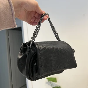 Zara väska  - Fint zara väska med kedja i bra skicka. Kommer inte med långt band. Kedjan kan hoppa av ibland (varit så sen jag köpte den). Men enklet att sätta dit kedjan igen. 