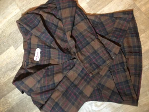 Supersöt brun skjorta - Jättefin och gullig brun skjorta med svarta och röda detaljer. Underbar över me t shirt eller stängd med en slips. Inte använd.