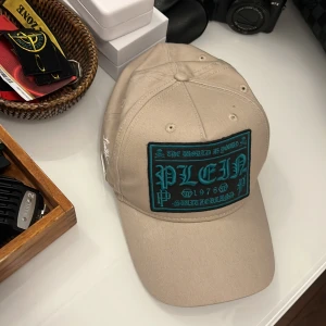 Philipp Plein keps  - Tjena säljer min Philip plen keps köpte den för cirka 2 månader sedan när jag var i Italien. Ny pris 2400. Säljer den för 1300 då den bara är använd några få gånger. Kvitto finns