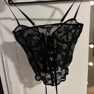 Spetstopp  - Snygg spetstopp från PLT. Funkar både som underkläder och festtopp. Storlek S, går att reglera med snörning i fram. Helt ny aldrig använd.