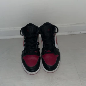 Jordan 1 Mid - Jordan 1 Mid Bred Toe  Storlek 35 Säljer de pga de är alldeles för små   Har tyvärr inge kvitto eller box men de var köpta på JD för länge sen   Ganska creasade och använda men skulle ändå säga att skicket var 7-8/10 Pris kan diskuteras