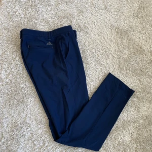 Adidas golfbyxor - Snygga Adidas golfbyxor i superskönt tunnt tyg som håller vid och vatten borta. Mycket fint skick. Marinblå. Strl 32/34 