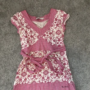 Kort klänning  - Väldigt kort klänning med knytning från bondelid. Ungefär 65 cm från axeln till slutet. 