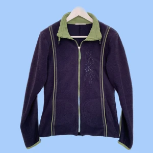 Fleecetröja - Fleecetröja med blixtlås och snygg brodering med glitterpärlor. Den är mörkblå med limegröna detaljer. Storlek s med mycket stretch, bör också passa M. Köpt secondhand. Har du frågor eller vill se fler bilder, skicka iväg ett meddelande!