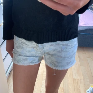 Heartless jeans shorts storlek s/ 34 - Säljer ett par shorts köpta i Paris då de inte kommer till användning, använda ca 2 ggr. De e i kamouflage och har ljus blåa stjärnor på!💗