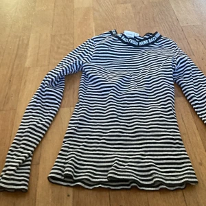 Rutig tröja  - Den är svar med vita ränder och sjön. Den är bra att ha på en vår dag. 