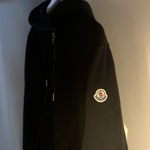 Moncler Logo Stripes Zip-Up Hoodie  - Hej, säljer en Moncler hoodie i utmärkt skick. Storlek L men passar även M. Har box från Luisaviaroma samt digitalt kvitto ifrån köp. Äkthet kan även checkas med QR och CLG koden på insidan av tröjan. Priset är inte hugget i sten. Hör av dig vid intresse.
