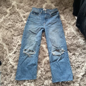 Baggy jeans - Baggy jeans som är mid waist och har hål i knäna och bara klippt lite vid fötterna 