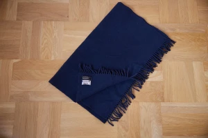 Acne halsduk i lammull  - Stor mörkblå halsduk med fransar i lammull. I använt skick men utan defekter.