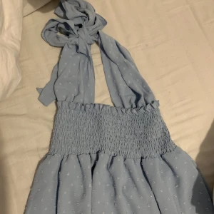 Klänningen  - En ljusblå klänning med knytning i storlek S-M