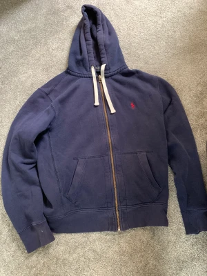 Ralph lauren  - Säljer min ralph lauren zip hoodie pga för stor storlek, nypris 1700kr på Care of Carl jag säljer för 650kr.  Finns en liten fläck längst ner på tröjan  inget som syns. 