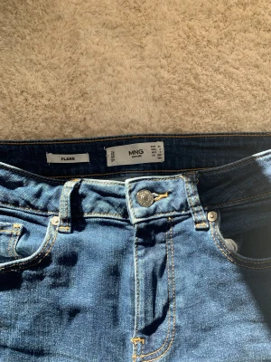 Bootcut - Supersnygga, oanvända mango jeans, men kommer inte till användning tyvärr. Jag är 1,71 centimeter och dom sitter till hälen på mig. Innerbenslängden är 78 cm och midjemåttet 70 cm. Skriv till mig om ni har övriga frågar. Frakt tillkommer, inga returer 