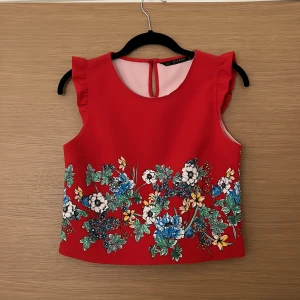 Gullig topp Zara stl XS - Gullig röd topp med blommor från ZARA i stl XS. Skicka meddelande för fler bilder.