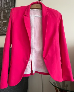 Fin kavaj i fuchsia!  - Fin fuchsia kavaj i jättefint skick! Den formar midjan och har vadderade axlar. Perfekt till vår eller sommar!