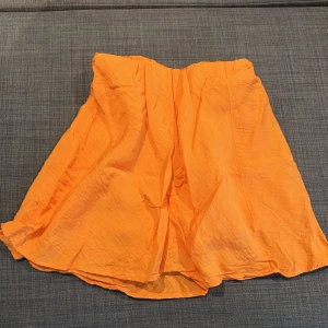 Kjol med inbyggda shorts - Kjol med inbyggda shorts från Gina tricot, väldigt fin orange färg som passar perfekt till sommaren. Aldrig använda i storlek XS.