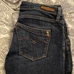 Lågmidjade Replay jeans - Superfina jeans från replay i nyskick. Köptes här på Plick men har själv aldrig använt dem då de inte är min stil. Väldigt långa på mig som är ca 150. Det står att midjestorleken är 28 men de passar mig som normalt sett har 25-26 i midjan. 31 cm rätt över
