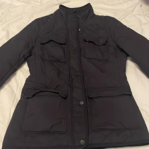 jacka  - snygg jacka som har två fickor uppe och nere jackan är tunn och i srlk 34