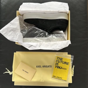 Axel Arigato skor - Axel Arigato svarta Platform Suede låga sneakers. Tillverkad av premium mocka läder. Skorna är i storlek 38 och är dessutom helt oanvända. Vid snabb affär kan priset diskuteras.