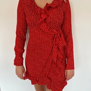 Prickig omlottklänning NAKD - Röd omlottklänning med vita prickar från NAKD. Volang upp- och nedtill.