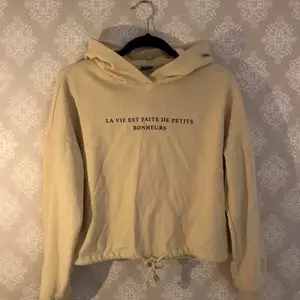 En croppad beige hoodie/tröja från GinaTricot, som endast använts ett fåtal gånger. Text över bröstet, samt snörning för att dra åt i midjan. Väldigt bra skick. 🤎 Hör av dig om du har några frågor!!