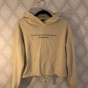 Beige hoodie/tröja - En croppad beige hoodie/tröja från GinaTricot, som endast använts ett fåtal gånger. Text över bröstet, samt snörning för att dra åt i midjan. Väldigt bra skick. 🤎 Hör av dig om du har några frågor!!