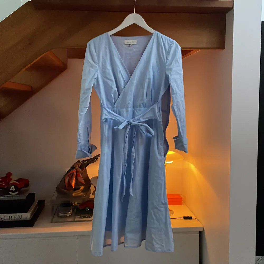 Ljusblå klänning från By Malina stl M. Dragkedja på sidan och knytband runt midjan. Kan skickas mot fraktkostnad . Klänningar.