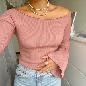 Rosa topp, ribbad - Ljusrosa topp i ribbat tyg i storlek S-M från Gina tricot. Vida ärmar och off shoulder. Använd ett fåtal gånger. 