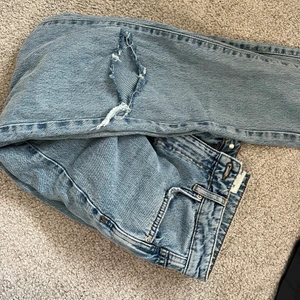 Jeans - Blåa jeans från Gina med slitningar. Storlek 36