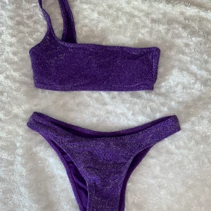 Glittrig bikini ✨ - Superfin glittrig lila bikini från Pull and bear! ✨✨ Är från deras kollektion förra året och går därför inte att köpa längre. Endast använd en gång och är därför i nyskick! 😍☀️ Båda delarna är i storlek S men skulle säga att toppen är åt det mindre hållet så passar därför även en XS! Är också därför jag säljer den. 🥰