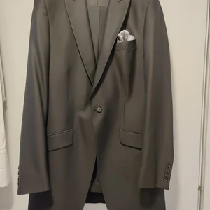 Cavaliere ceremony bröllopskostym - Kostym inköpt för bröllop. Jacka och väst i strl 52, skjorta i strl M byxor har strl 92 i midja och 89 i benlängd. Finns även ett par svarta lackskor i strl 43. Plus 3 snusnäsdukar (2 orangea och 1 grå och 1 orange fluga)