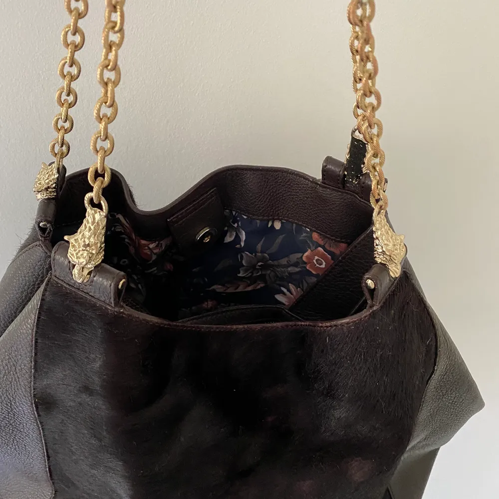 Brun väska från Uterqüe i äkta skinn och älta kopäls. Guldiga detaljer. Tyvärr har pälsen nötts på baksidan där väskan ofta är mot kroppen. Syns alltså inte utifrån. 4 fack, rymlig . Väskor.