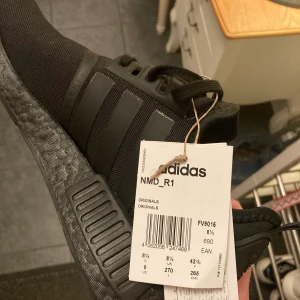 Adidas NMD R1 Triple Black - Helt nya skor, endast testade en gång. Säljes eftersom skorna var för små. Box ingår ej.                                            Kan mötas upp i Umeå eller frakta vid behov. Köpare står för frakt.  Pris kan diskuteras vid snabb affär. Nypris 1500 :-