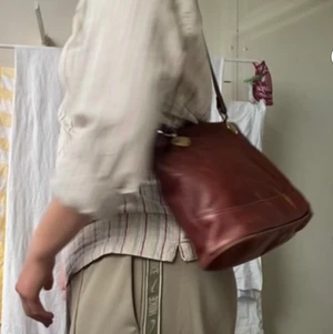 SNYGG BRUN AXELVÄSKA - ❗️FRAKT INGÅR I PRISET❗️Sexii brun läderväska med långa axelband och coola gulddetaljer. 🔱 Nästintill oavvänd! Har innerficka och båda dragkjedjorna är i bra skick. Skulle tro att det är äkta läder men ej säkert. Kan mötas upp i Sthlm eller frakta och Pris kan diskuteras💥