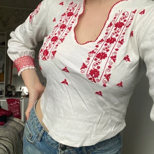 Stella Forest broderad top  - Broderad lite kortare top från Slella Forest. Lätt skada på broderi-tråden längst ned på högra ärmen. Storlek ej utskriven, men passformen syns på bilden på en person med storlek M. 