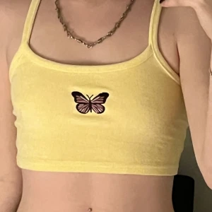 Gul fjärils topp från Bershka - En somrig o härlig fjärils topp från bershka!☀️☀️ Har använts men är som ny då den inte är sönder eller urtvättad alls! Ganska stretchig o långa axelband så passar säkert fler storlekar än XS