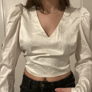 Långärmad blus från XLE - Vit långärmad blus från XLE i storlek XS. Den är croppad med öppen rygg som man knyter. Säljer för 100 kr eller bud med rätt att neka. Köparen står för frakten 😊